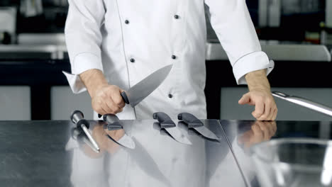 Chef-choosing-knife-to-cook-at-kitchen.-Closeup-man-hands-preparing-to-cook.