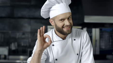 Chef-Feliz-Haciendo-Un-Buen-Gesto-En-La-Cocina-Comercial.-Hombre-Chef-Posando-En-La-Cocina