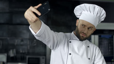 Koch-Macht-Foto-In-Der-Küche.-Porträt-Eines-Kochs,-Der-Ein-Selfie-Mit-Dem-Mobiltelefon-Macht.