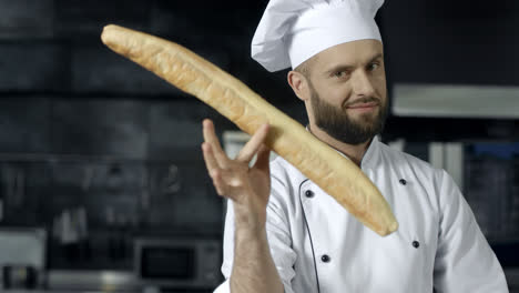 Chef-making-fun-with-french-bread-at-kitchen.-Closeup-man-hands-play-with-bread.