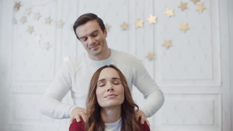 Smiling-couple-relaxing-with-massage-in-christmas-decorated-room.