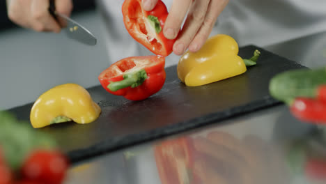 Chef-cooking-food-at-kitchen-restaurant.-Closeup-chef-hands-cutting-red-pepper.