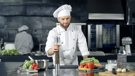Professional-chef-preparing-to-cook-at-kitchen.-Chef-warming-up-with-pepperbox