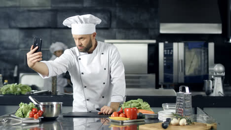 Chef-Masculino-Tomando-Una-Foto-Selfie-En-La-Cocina.-Chef-Profesional-Con-Cuchillo