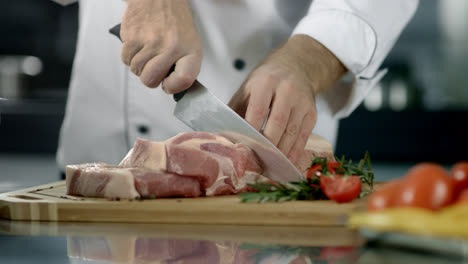 Chef-hands-cutting-pork-fillet-at-kitchen.-Chef-hands-cutting-fresh-meat