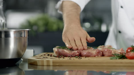 Chef-male-preparing-meat-at-kitchen.-Closeup-chef-hands-preparing-steak.