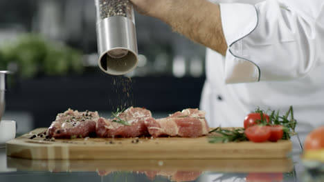 Chef-Masculino-Salpicando-Carne-En-La-Cocina.-Primer-Plano,-Chef,-Manos,-Pimienta,-Bistec