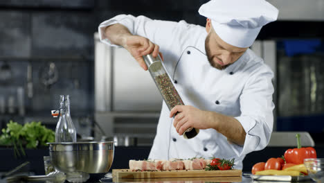 Chef-Masculino-Salpicando-Carne-En-La-Cocina.-Primer-Plano,-Chef,-Pimienta,-Bistec,-En,-Lugar-De-Trabajo
