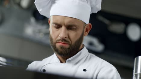 Chef-man-portrait-at-professional-kitchen.-Chef-cooking-food-in-slow-motion