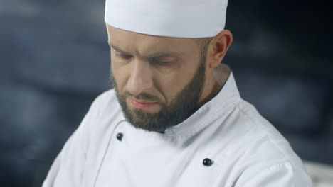Chef-man-working-at-professional-kitchen.-Close-up-chef-face-cooking-food