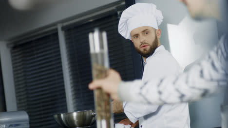 Man-chef-cooking-in-wok-at-kitchen.-Focused-chef-preparing-asian-food