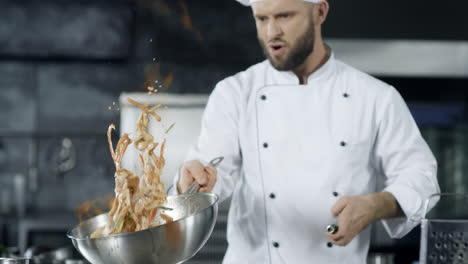 Chef-cooking-food-with-burning-fire-in-slow-motion.-Focused-chef-throwing-food