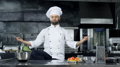 Chef-Hombre-Posando-En-La-Cocina-Profesional.-Chef-Burlándose-En-Pose-De-Meditación.