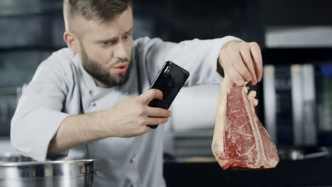 Chef-Haciendo-Fotos-De-Carne-Con-Teléfono-Móvil.-Chef-Masculino-Tomando-Fotos-De-Bistec.
