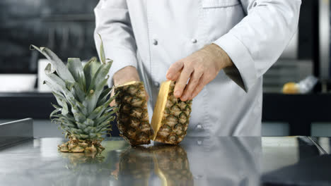 Chef-cutting-pineapple-in-slow-motion.-Closeup-chef-hands-chopping-fresh-fruit.
