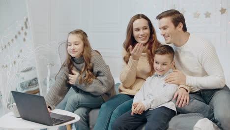 Lächelnde-Familie,-Die-Sich-Gemeinsam-Im-Wohnzimmer-Ein-Video-Auf-Dem-Laptop-Ansieht.