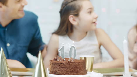 Portrait-of-smiling-girl-blowing-birthday-candles-in-luxury-house.