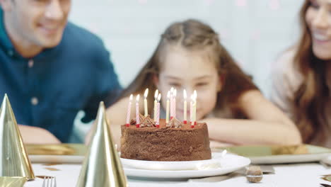 Closeup-smiling-birthday-girl-blowing-12-birthday-candles-in-luxury-house.