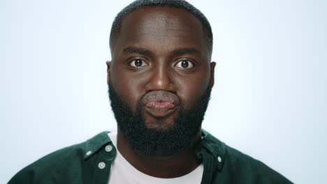 Portrait-of-positive-african-man-making-funny-faces-in-grey-background.