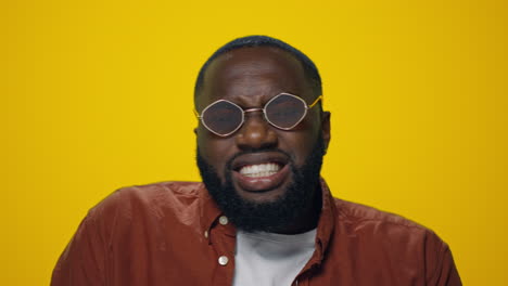 Portrait-of-bearded-african-american-man-dancing-on-yellow-background.