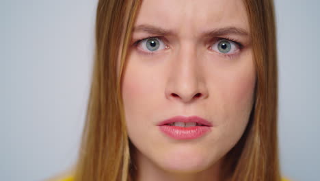 Closeup-angry-woman-shouting-with-aggressive-emotion-at-camera-in-studio.
