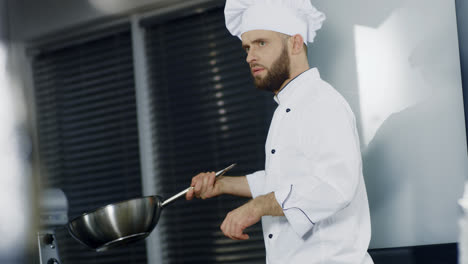 Chef-cooking-in-wok-at-kitchen-restaurant.-Man-chef-preparing-asian-food-in-pan