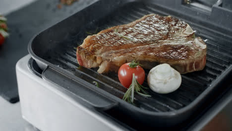 Fresh-steak-frying-at-griddle-pan.-Closeup-beef-with-vegetables-cooking-at-grill