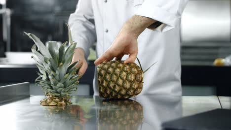 Chef-chopping-pineapple-in-slow-motion.-Man-chef-cutting-fresh-fruit.