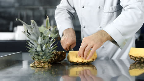 Chef-hands-slicing-pineapple-in-slow-motion.-Chef-hands-chopping-fresh-fruit