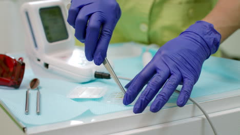Stomatolog-preparing-dentistry-tools.-Dentist-hands-preparing-dental-turbine