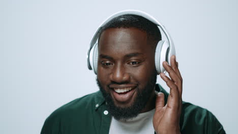 Porträt-Eines-Positiven-Afrikanischen-Mannes,-Der-Im-Studio-über-Kopfhörer-Musik-Hört.