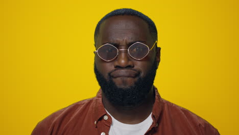 Portrait-of-afro-handsome-man-making-funny-faces-on-yellow-background.