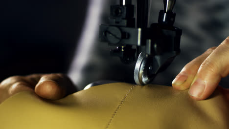 Leather-sewing-machine.-Close-up-craftsman-hands-stitching-leather-material