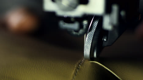 Tailor-working-on-sewing-machine-at-textile-factory.-Close-up-leatherworker-hand