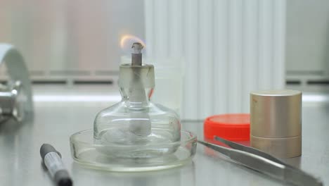 Candle-stick-with-fire-on-laboratory-table.-Fire-flame-in-lab-beaker