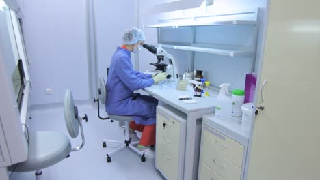 Lab-technician-using-laboratory-microscope.-Researcher-doing-experiment