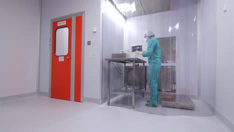 Female-worker-in-uniform-working-in-sterile-room-at-pharmaceutical-factory