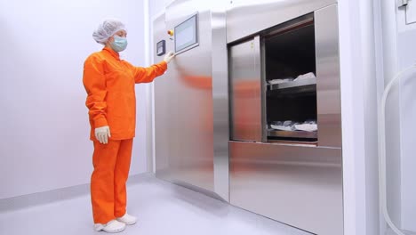 Factory-worker-using-touch-screen-panel-to-close-refrigerator-storehouse