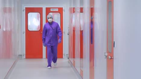 Pharmaceutical-factory-worker.-Doctor-in-face-mask-moving-in-hospital-corridor
