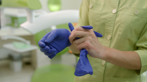 Female-nurse-wearing-latex-gloves-in-modern-clinic.-Close-up-dentist-hands