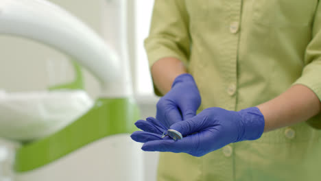 Stomatolog-preparing-dental-mirror-and-probe.-Close-up-woman-hands
