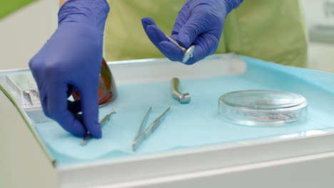 Dentist-hands-taking-dentistry-tools-from-table.-Stomatolog-taking-dental-mirror
