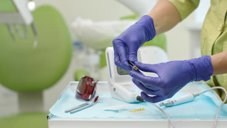 Stomatolog-hands-in-latex-gloves-holding-dental-turbine.-Close-up-dentist-hands