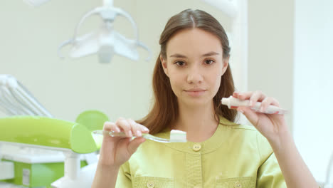 Beautiful-girl-squeezing-toothpaste-on-toothbrush.-Stomatology-assistant