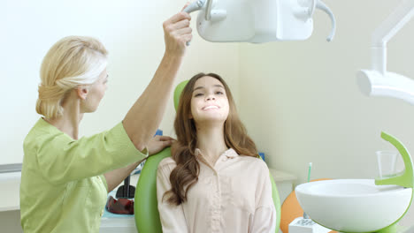Zahnarzt-Justiert-Die-Zahnlampe-Am-Zahnarztarbeitsplatz.-Stomatologe