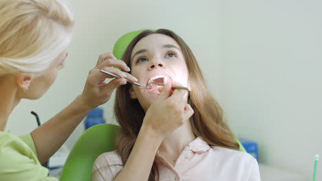 Young-woman-having-teeth-examination-at-dentist.-Professional-oral-checkup