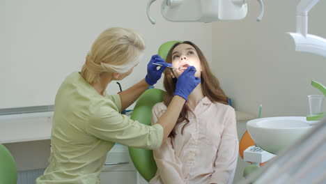 Tratamiento-De-Caries-Dental-En-Consultorio-Dental.-Mujer-Con-La-Boca-Abierta-En-La-Silla-Del-Dentista
