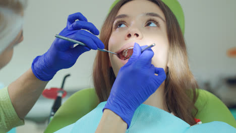 Dentista-Femenina-Examinando-Los-Dientes-Del-Paciente-Con-Herramientas-Dentales.-Tratamiento-Médico
