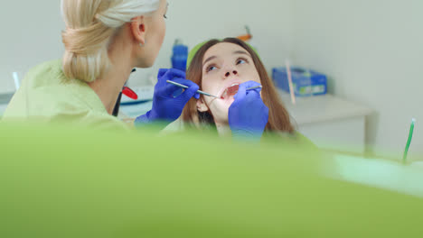 Niña-Que-Se-Somete-A-Un-Chequeo-Dental-Regular.-Mujer-Joven-Visitando-A-Su-Dentista.