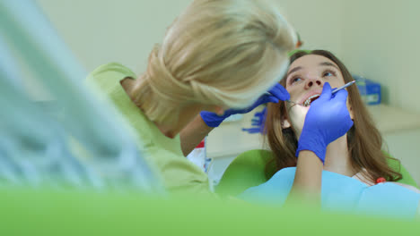 Young-woman-having-regular-teeth-examination-at-family-dentist